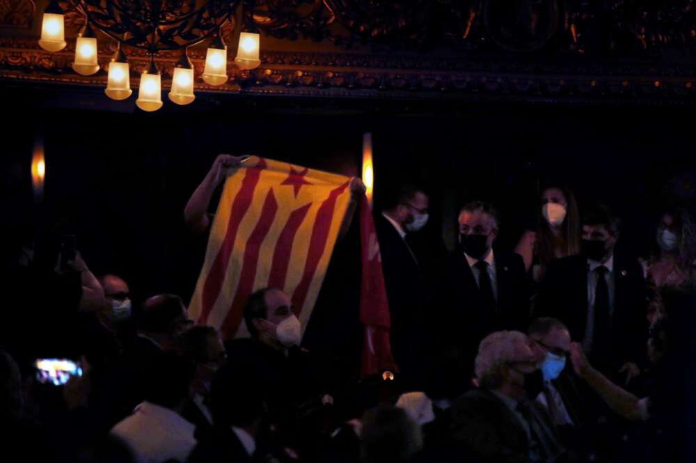 Una persona muestra una bandera independentista durante la conferencia que el presidente del Gobierno, Pedro Sánchez, pronuncia en el Teatre del Liceu de Barcelona ante representantes políticos y de la sociedad civil, en vísperas de los posibles indultos a los líderes del procés presos. EFE/Toni Albir