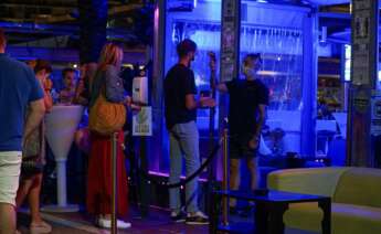 Un empleado toma la temperatura a un joven que hace cola para entrar en un pub en el puerto deportivo de Marbella. EFE/Antonio Paz/Archivo