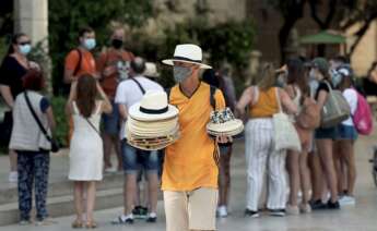 La mitad de los españoles no confía en que la recuperación llegue en 2023. En la imagen, un hombre vende sombreros en una calle de Valencia. EFE/ Biel Aliño/Archivo