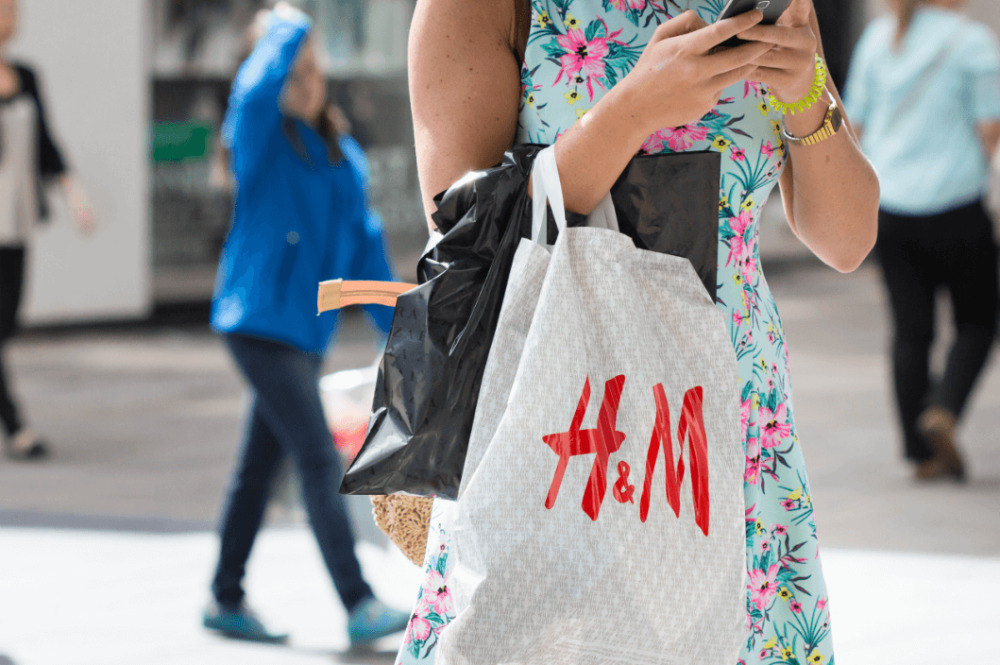 Una mujer con una bolsa de una tienda de H&M