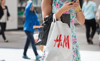 Una mujer con una bolsa de una tienda de H&M