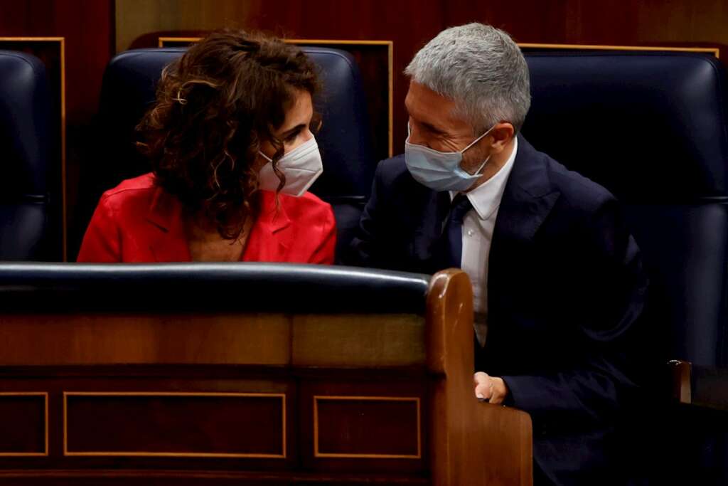 La ministra de Hacienda, María Jesús Montero, conversa con el responsable de Interior, Fernando Grande-Marlaska, durante la sesión de control al Gobierno este miércoles en el Congreso de los Diputados. EFE/Juan Carlos Hidalgo