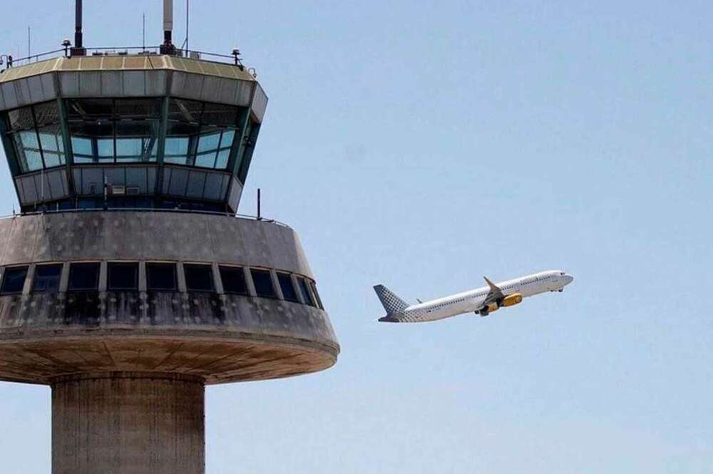 En la imagen, un avión despega ante la torre de control del aeropuerto de El Prat. / EFE