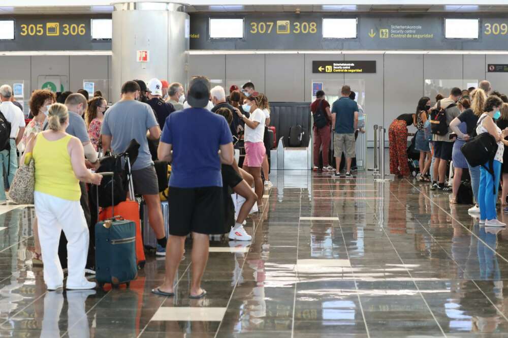 Turistas hacen cola en para viajar en el aeropuerto