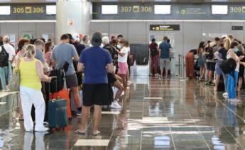 Turistas hacen cola en para viajar en el aeropuerto
