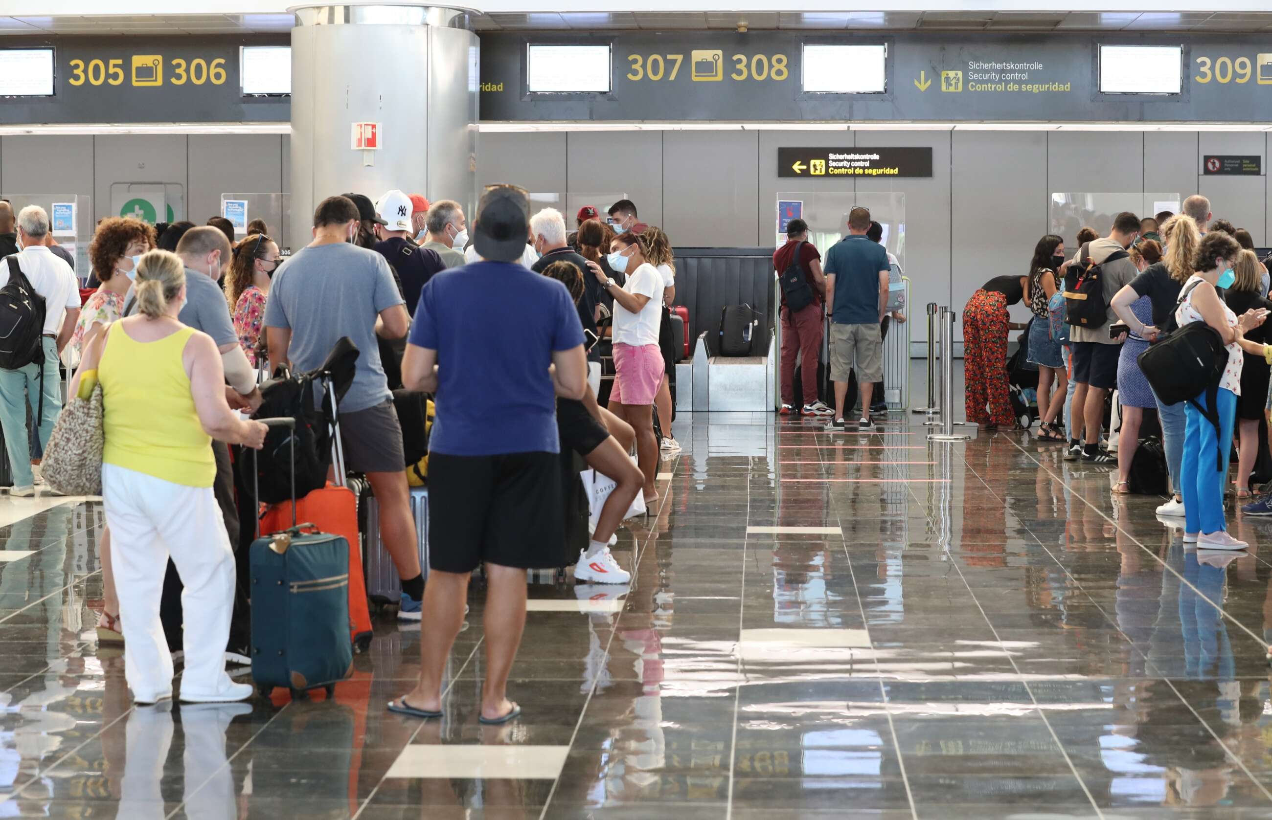 Turistas hacen cola en para viajar en el aeropuerto