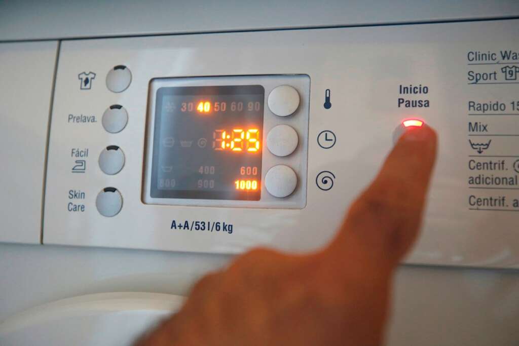 La luz bate un nuevo récord en España y llega a los 383 euros por megavatio hora. En la imagen, una persona prepara una lavadora. EFE