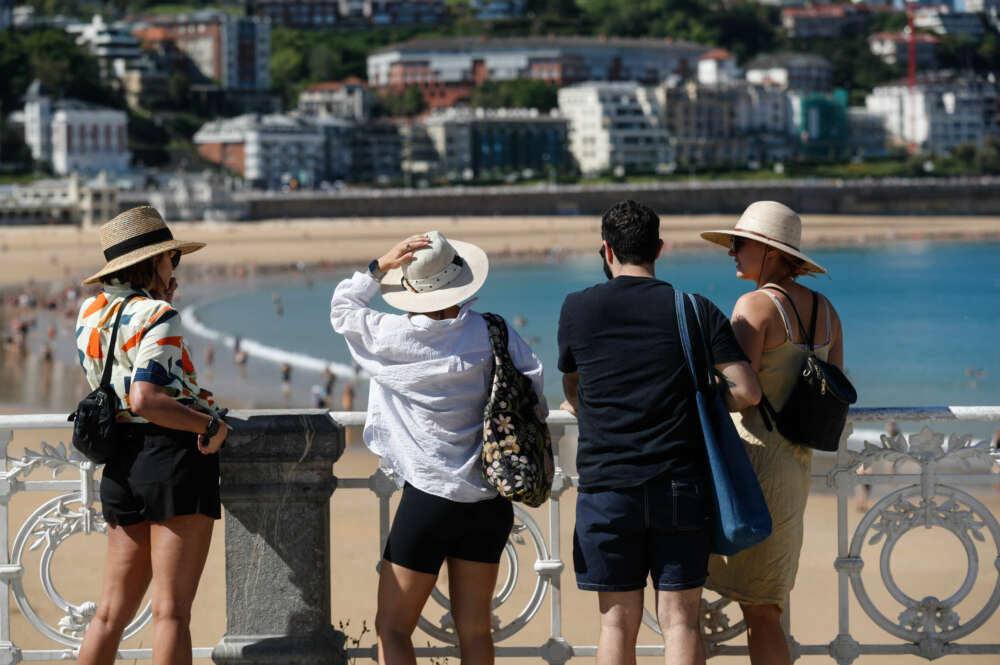 GRAFCAV5519. SAN SEBASTIÁN (ESPAÑA), 17/05/2022.- Unos turistas visitan la playa de la Concha de San Sebastián. Los cielos del País Vasco se presentan este martes despejados, con intervalos de nubes altas por la tarde, las temperaturas ascenderán ligeramente y el viento soplará del suroeste flojo a moderado. EFE/Juan Herrero.