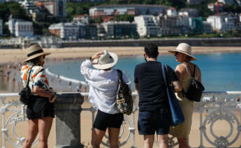 GRAFCAV5519. SAN SEBASTIÁN (ESPAÑA), 17/05/2022.- Unos turistas visitan la playa de la Concha de San Sebastián. Los cielos del País Vasco se presentan este martes despejados, con intervalos de nubes altas por la tarde, las temperaturas ascenderán ligeramente y el viento soplará del suroeste flojo a moderado. EFE/Juan Herrero.