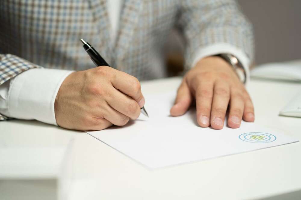 Hombre firmando un documento oficial. Imagen: Pixabay. cuenta.