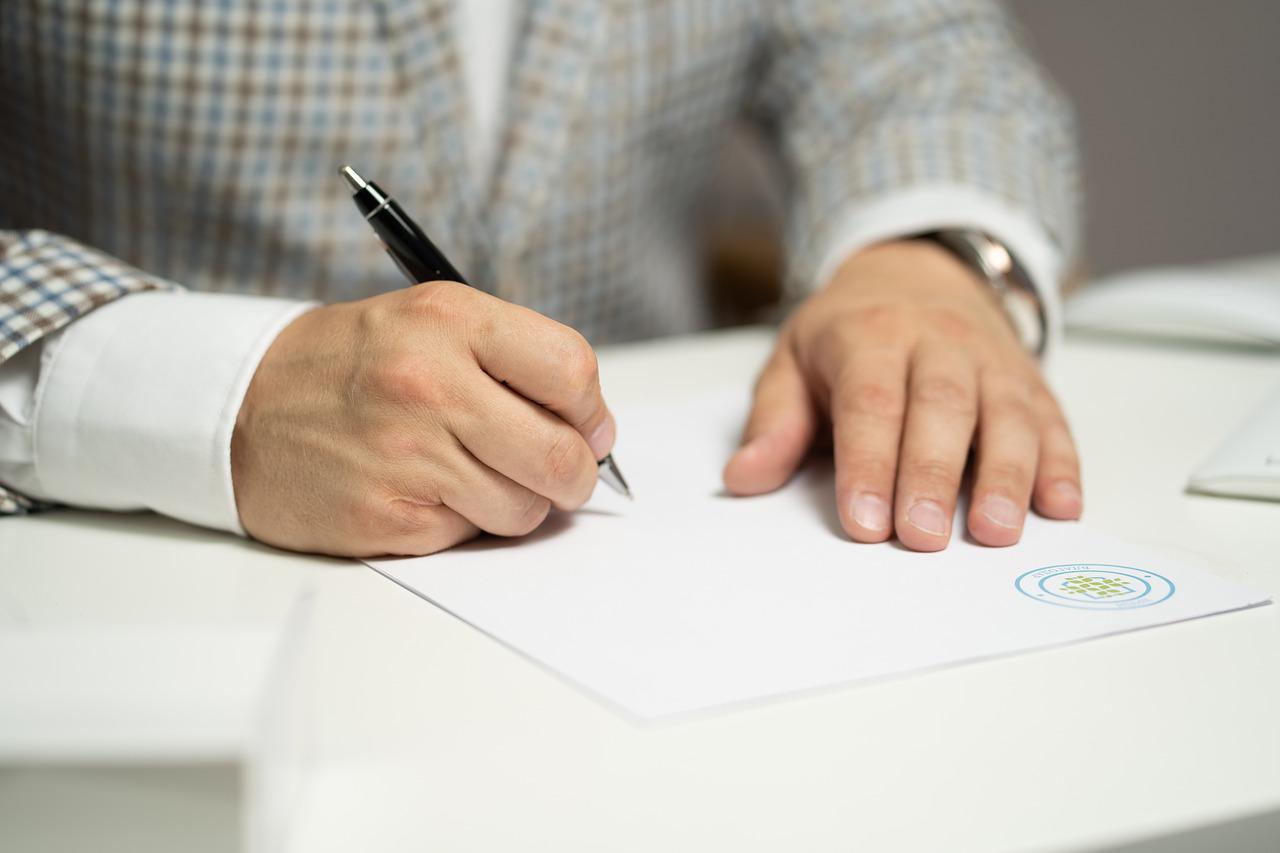 Hombre firmando un documento oficial. Imagen: Pixabay. cuenta.