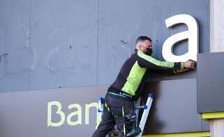 Los operarios desmontan el rótulo de Bankia de la sede principal del banco en Logroño, en 2021. EFE/Abel Alonso