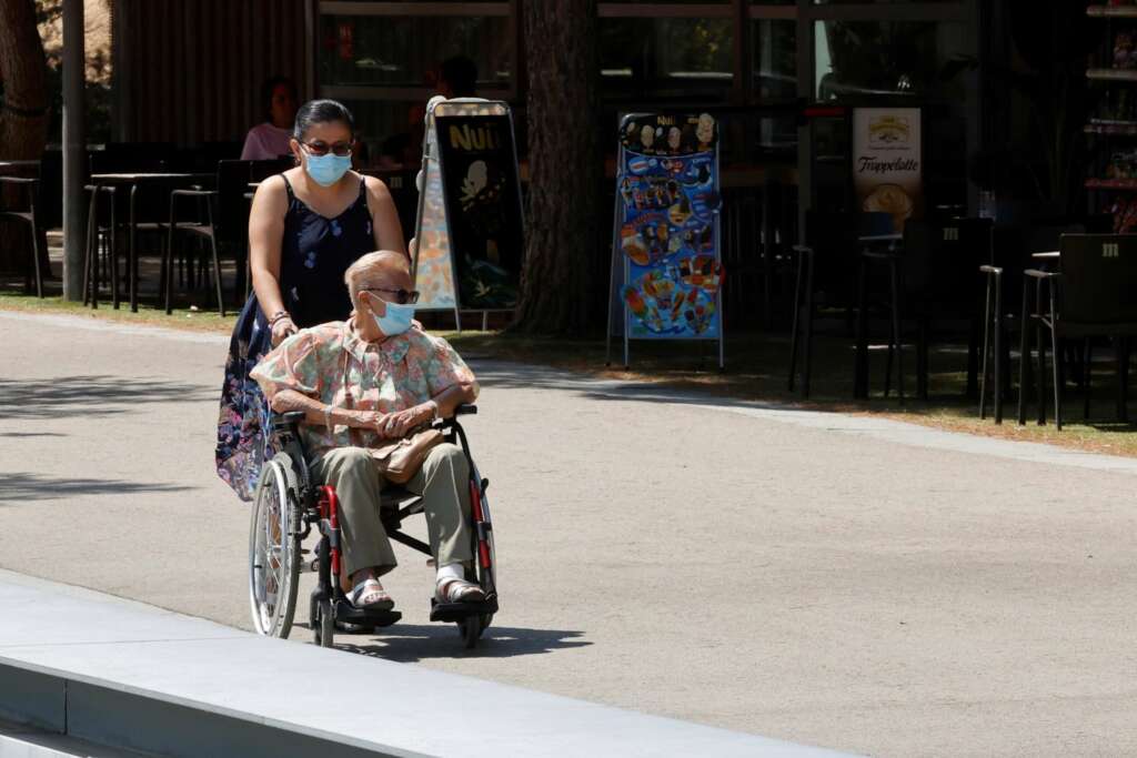 MADRID, 26/07/2021.- Una persona mayor es sacada a pasear por Madrid Río, este lunes, cuando se celebra el Día de los Abuelos. EFE/Zipi