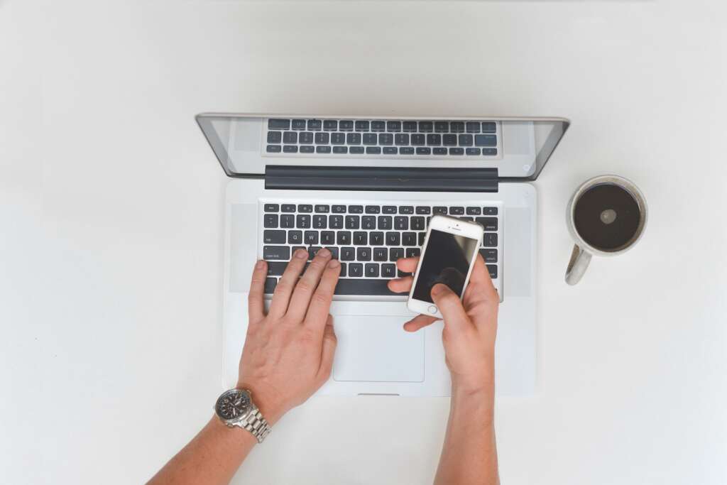 Una persona trabaja con un ordenador y un móvil. Foto: Pixabay.