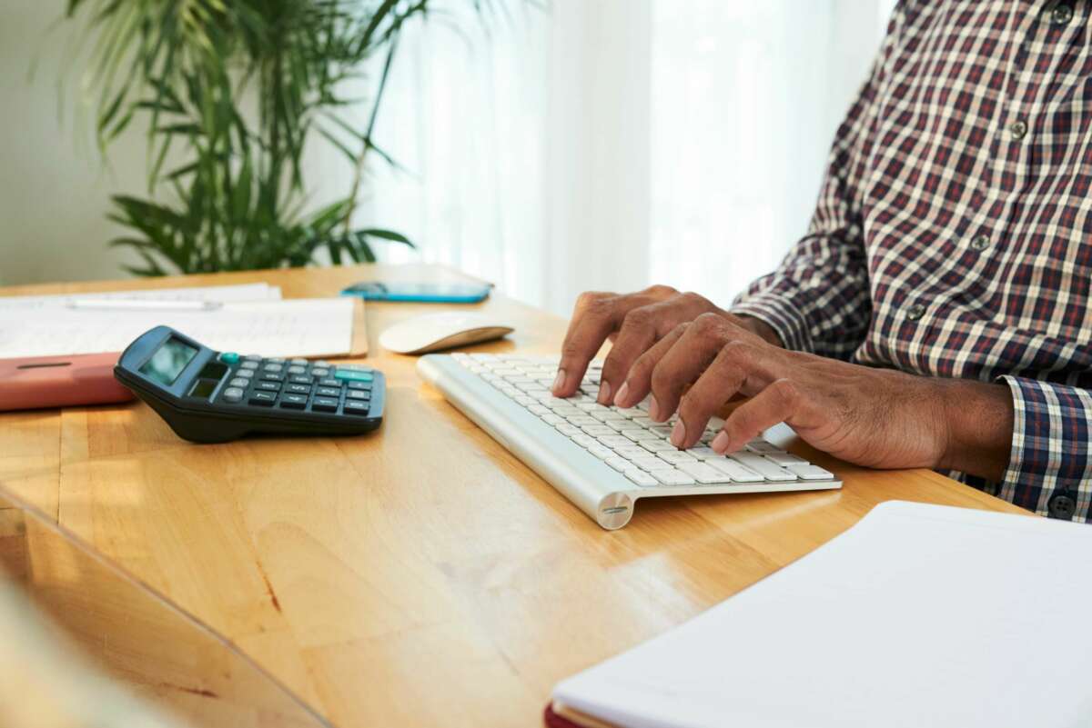 Un hombre mayor realiza un cálculo en un escritorio. Foto: Freepik.