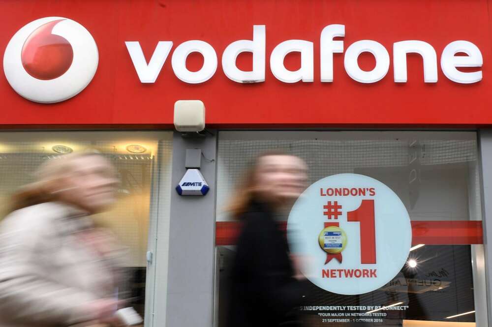 EPA2676. LONDRES (REINO UNIDO), 09/05/2018.- Foto de archivo de varios viandantes mientras pasan delante de un establecimiento de la compañía de telecomunicaciones Vodafone en Londres (Reino Unido) el 20 de marzo de 2017. Vodafone ha acordado la adquisición de las operaciones de la estadounidense Liberty Global en Alemania, República Checa, Hungría y Rumanía, en una transacción valorada en 18.400 millones de euros, según anunció la compañía hoy, 9 de mayo de 2018. EFE/Andy Rain