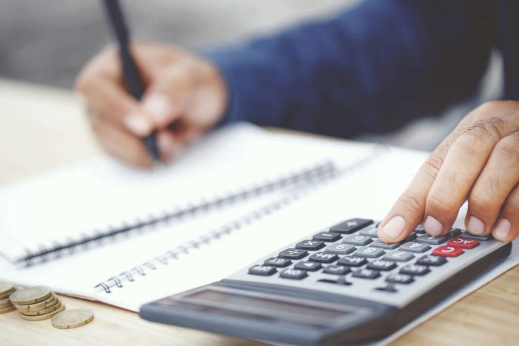 Una persona realiza un cálculo en la calculadora. Renta. Foto: Freepik.