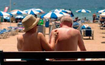 Dos jubilados toman el sol en la playa. Foto: EFE.