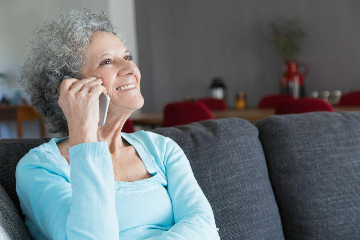 Una mujer mayor llama por teléfono. Foto: Freepik.