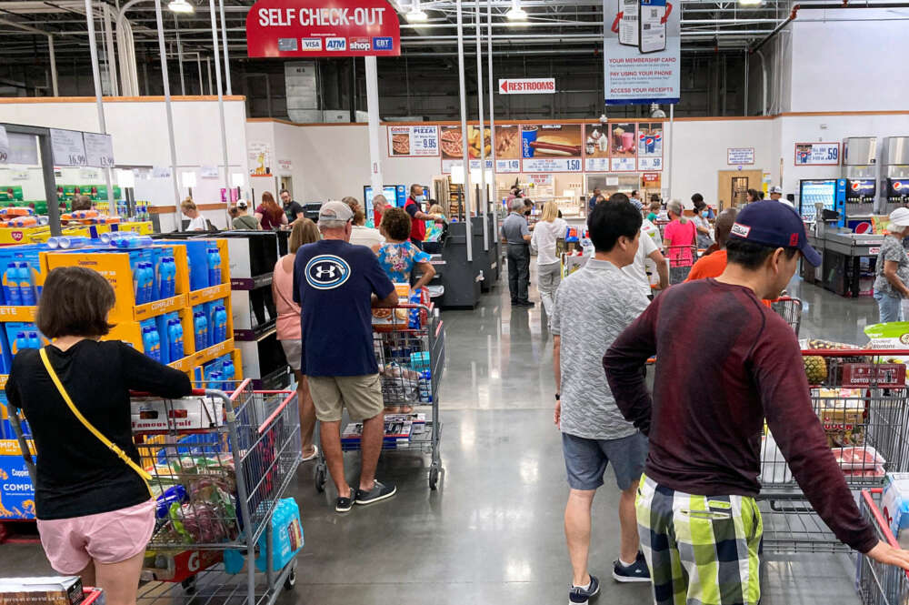 Varias personas esperan su turno en la cola de la caja de un supermercado Costco