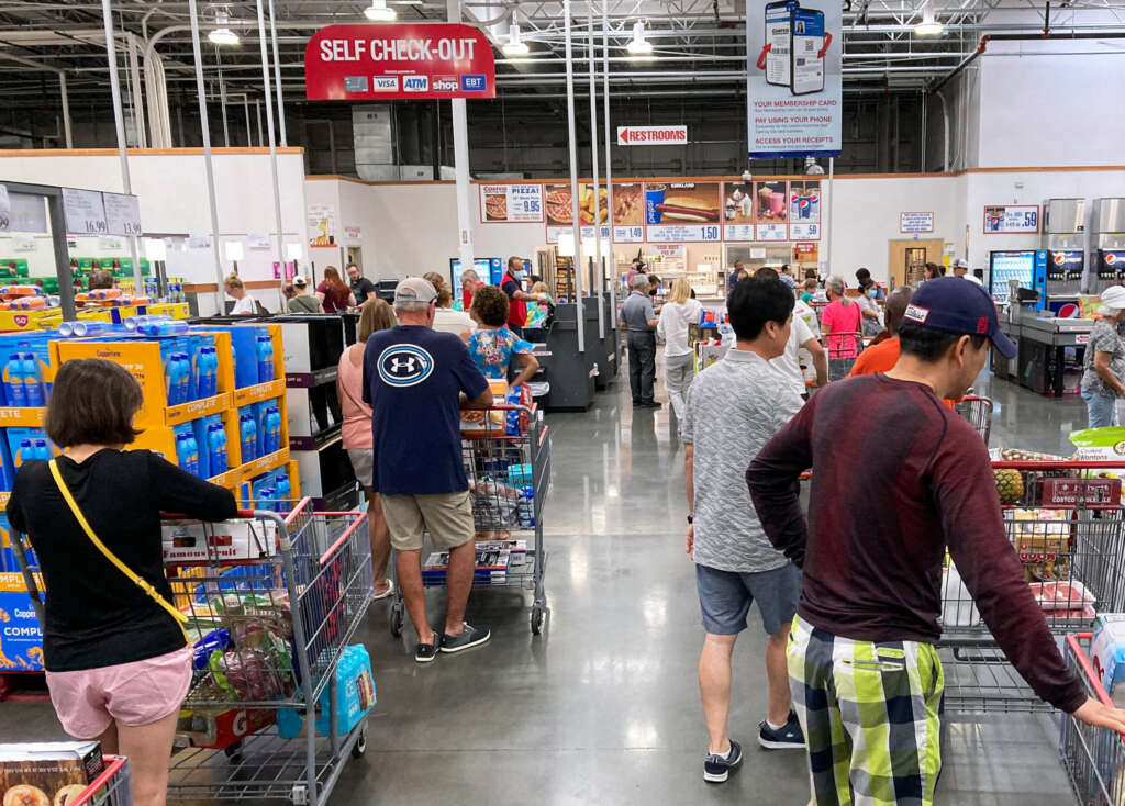 Varias personas esperan su turno en la cola de la caja de un supermercado Costco