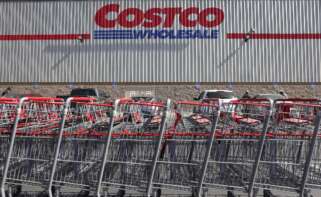 La fachada de Costco con su logo y una fila de carritos de la compra enfrente