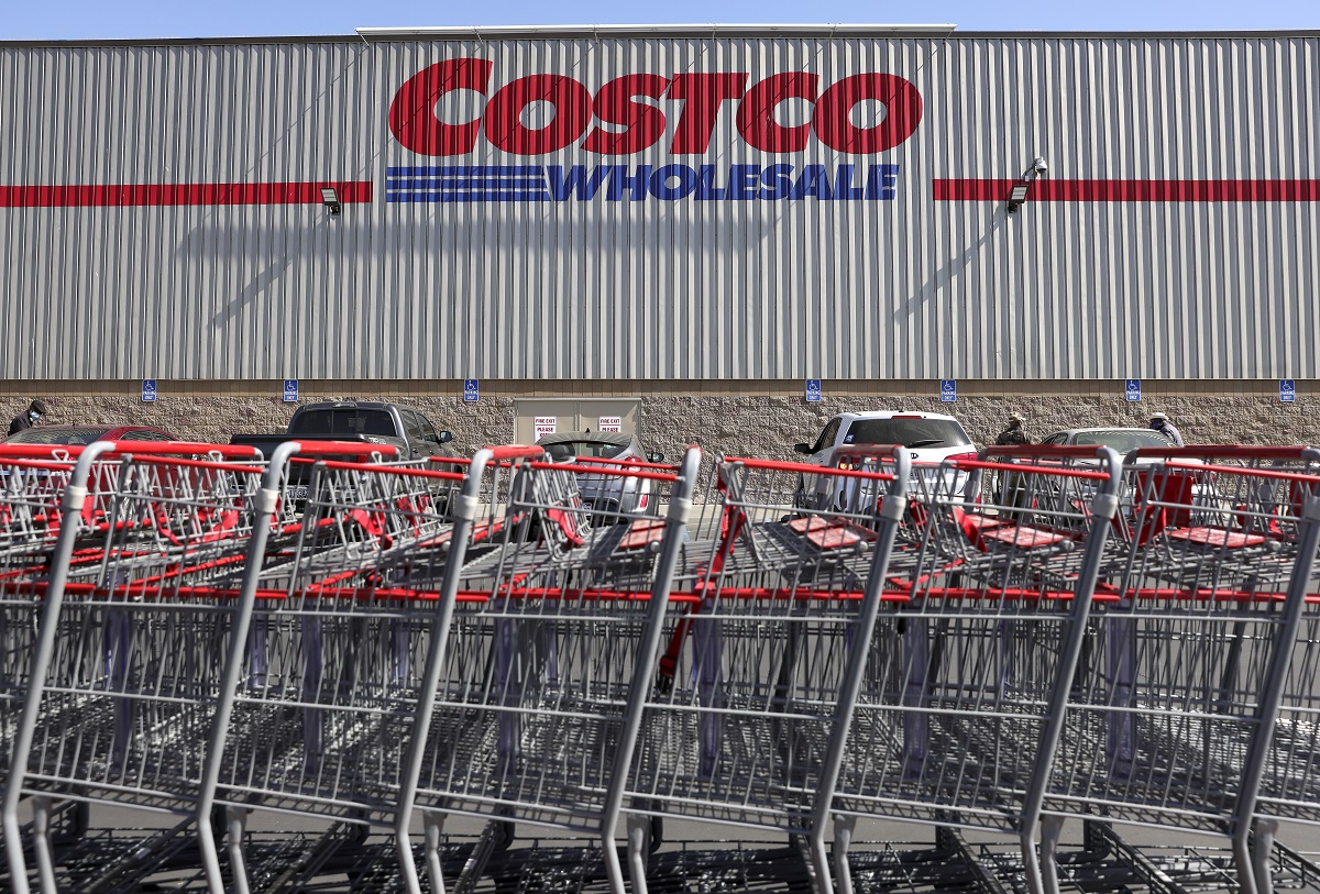 La fachada de Costco con su logo y una fila de carritos de la compra enfrente