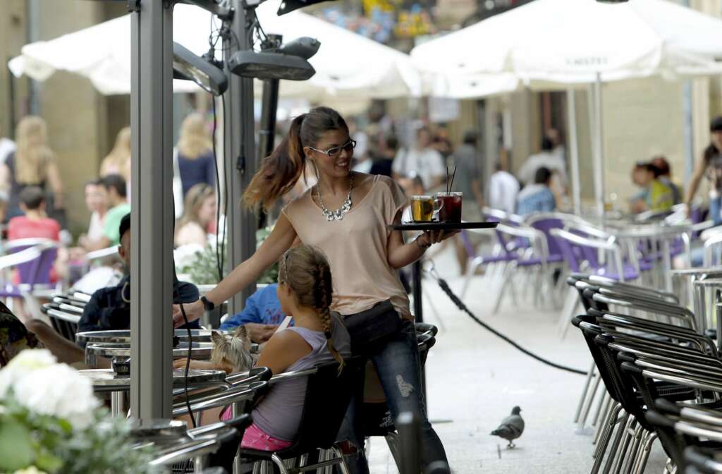 Una camarera reparte una consumición en una terraza. EFE/Javier Etxezarreta