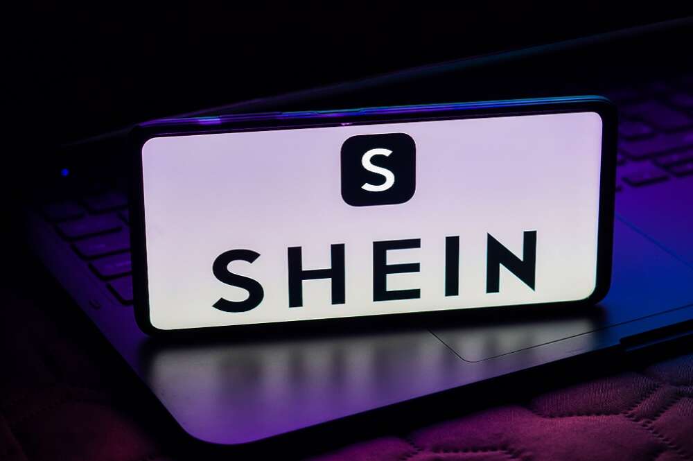 Un móvil sobre un ordenador con el logo de Shein en la pantalla