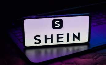 Un móvil sobre un ordenador con el logo de Shein en la pantalla