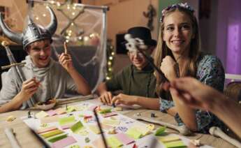 Unos niños juegan a unos juegos de mesa disfrazados de Halloween