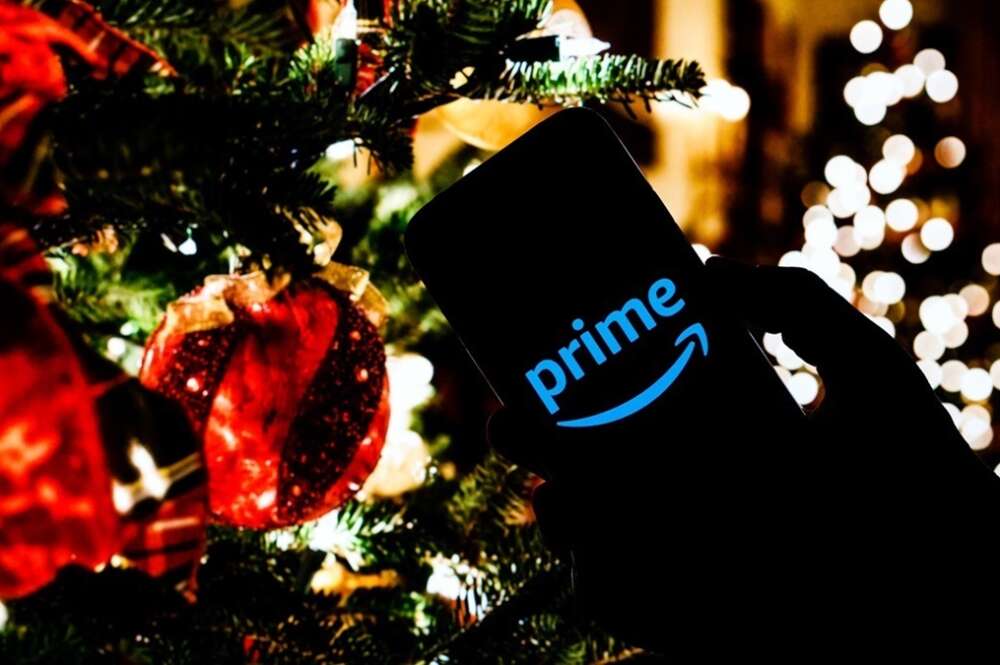 Un móvil con la aplicación de Amazon frente a un árbol de Navidad