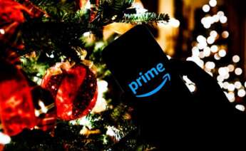 Un móvil con la aplicación de Amazon frente a un árbol de Navidad