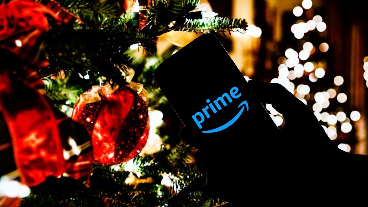 Un móvil con la aplicación de Amazon frente a un árbol de Navidad