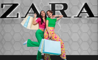 Dos chicas con bolsas de compras delante del logo de Zara