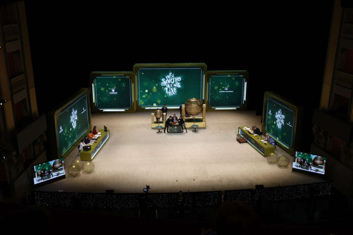 MADRID, 22/12/2023.- Dos niños de San Ildefonso cantan los números y sus correspondientes premios ante uno de los representantes de Loterías durante el sorteo extraordinario de Navidad de la Lotería Nacional este viernes en el Teatro Real de Madrid. EFE/ J.J. Guillén