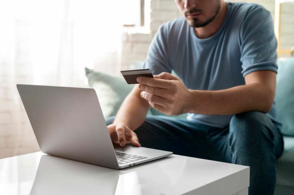 Un hombre hace una compra online con su tarjeta bancaria