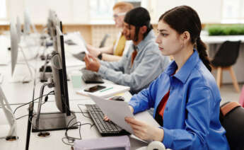 Una chica enfrente del ordenador buscando la Declaración de la Renta de años anteriores