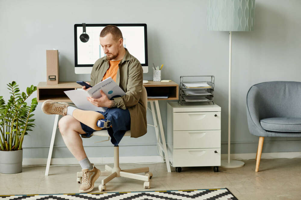 Hombre con discapacidad leyendo un documento en el lugar de trabajo