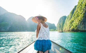 Mujer en un barco de cola larga en Tailandia