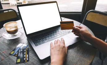 Una mujer sostiene una tarjeta de crédito para comprar online