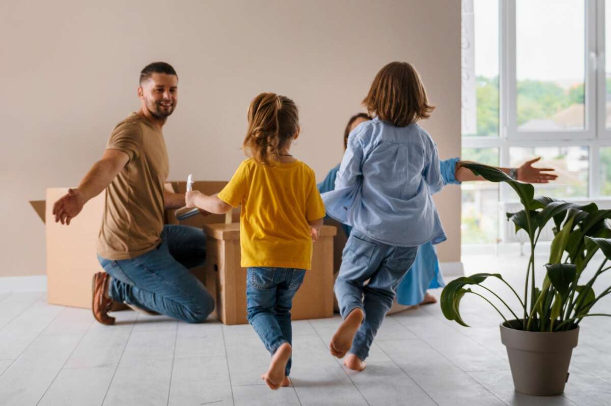 Unos niños corren hacia sus padres mientras terminan la mudanza a una nueva casa. Foto: Freepik.