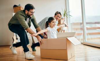 Una familia juega con una niña en la casa con la caja de la mudanza. Foto: Freepik.