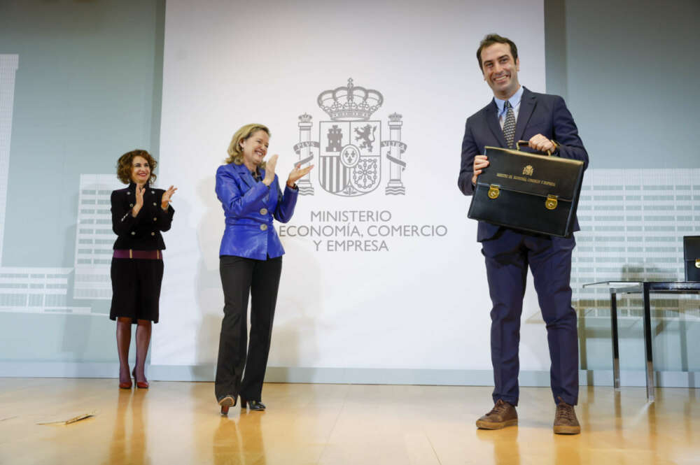 El nuevo ministro de Economía, Carlos Cuerpo (d) recibe la cartera de manos de su antecesora en el cargo, Nadia Calviño (c) en presencia de María Jesús Montero (i), nueva vicepresidenta primera. EFE/ Juan Carlos Hidalgo