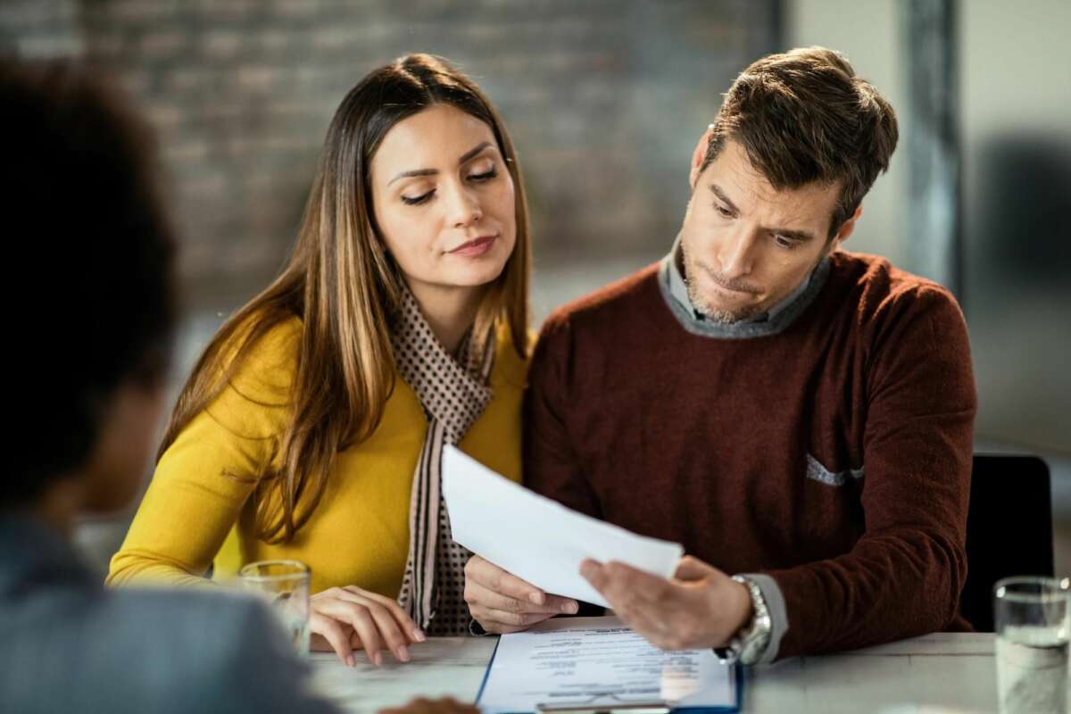 Una pareja consulta unos papeles en una oficina. Foto: Freepik.