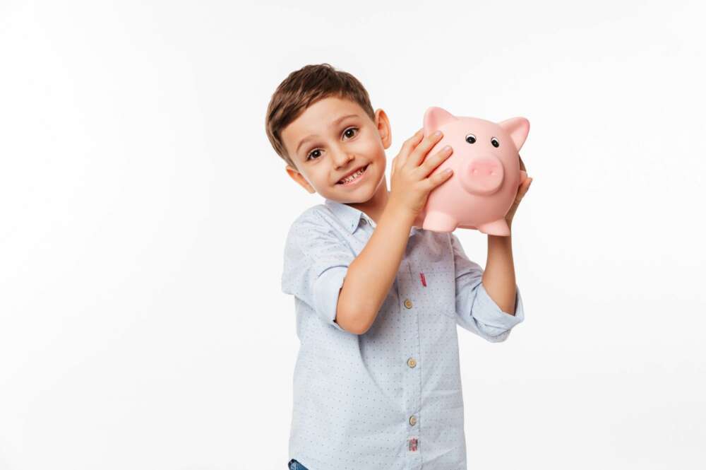 Un niño feliz con sus ahorros en la hucha