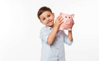 Un niño feliz con sus ahorros en la hucha