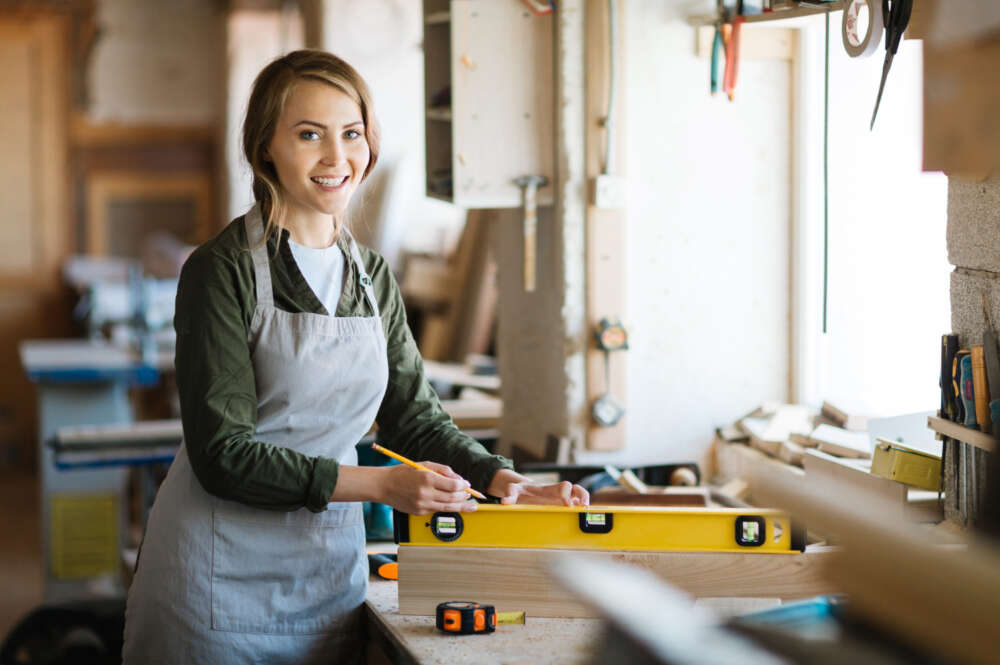 Una mujer autónoma trabaja en su taller de carpintería