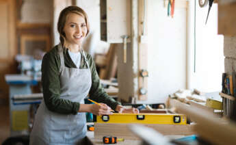 Una mujer autónoma trabaja en su taller de carpintería