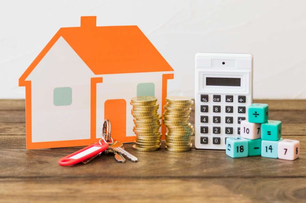 En la imagen aparece una vivienda, unas llaves, monedas, una calculadora y bloques con letras. Foto: Freepik.